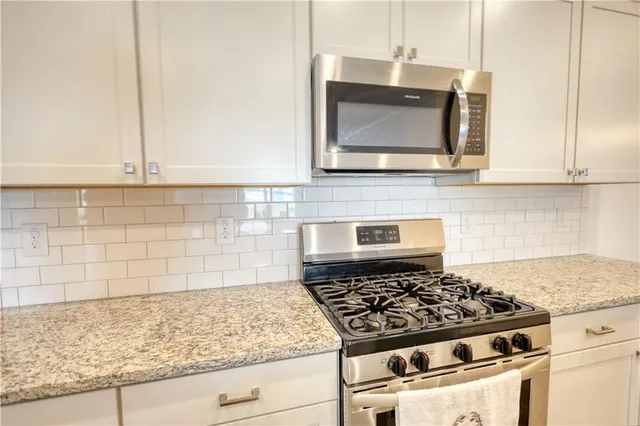 a kitchen with granite countertop a stove and a microwave