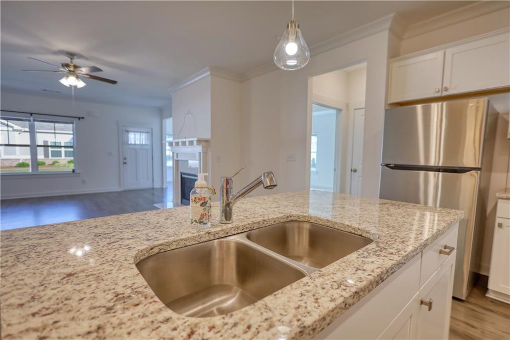 2929 Rambler Drive Loganville, GA 30052 - Photo 19 of 49 a kitchen with a sink a refrigerator and chandelier