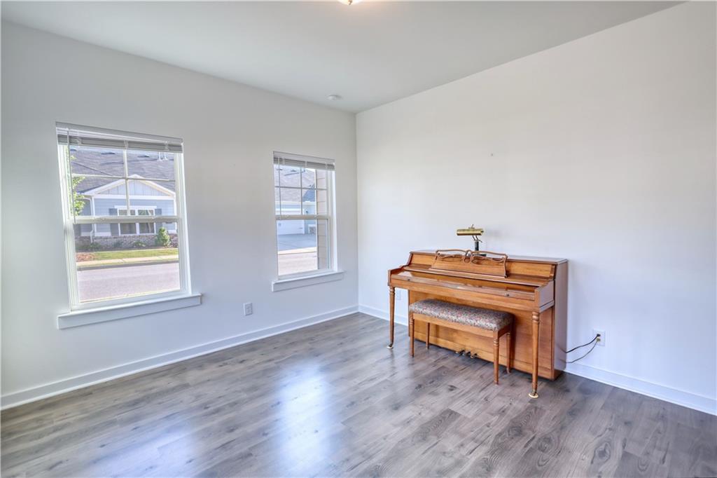 2929 Rambler Drive Loganville, GA 30052 - Photo 29 of 49 a room with a piano and wooden floor