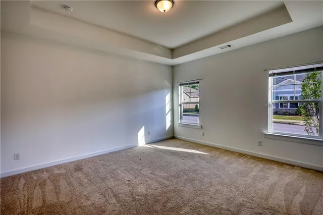 a view of an empty room with closet and a window