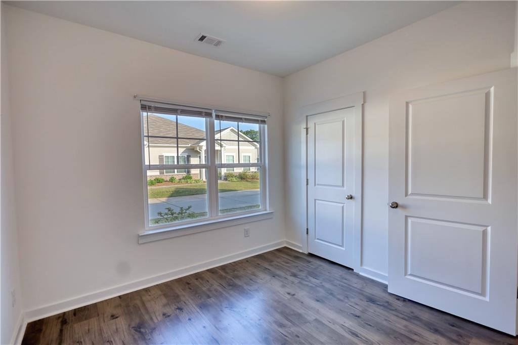 2929 Rambler Drive Loganville, GA 30052 - Photo 40 of 49 an empty room with wooden floor and windows