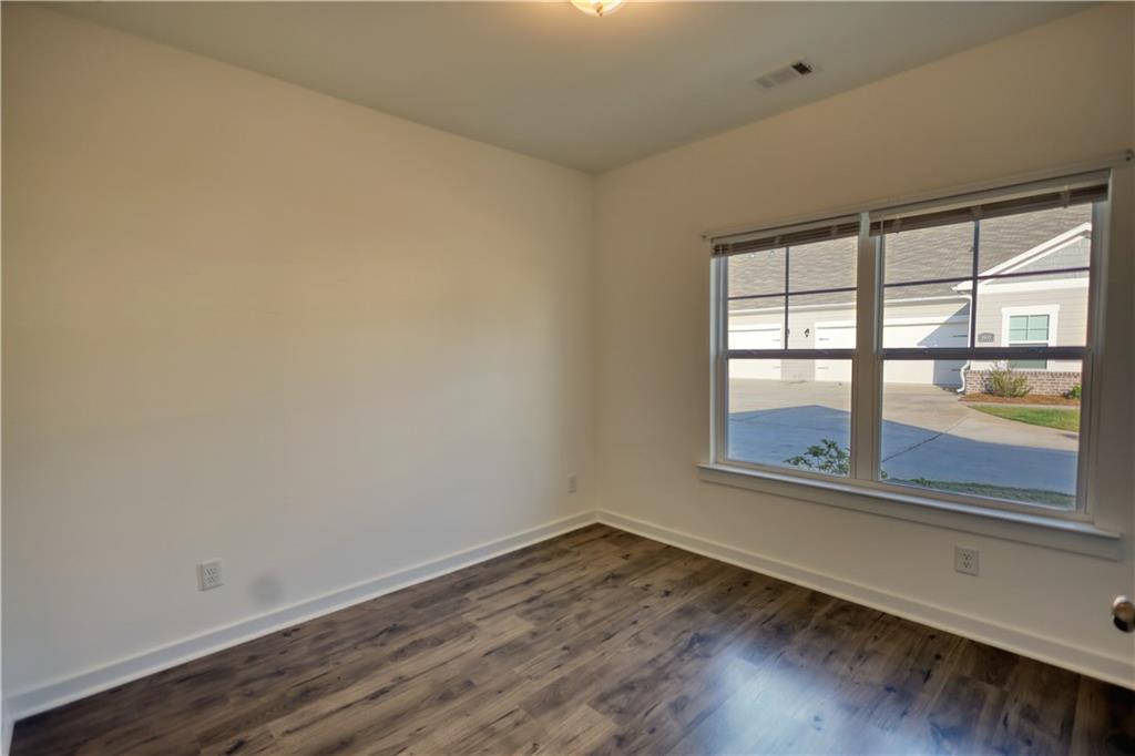 2929 Rambler Drive Loganville, GA 30052 - Photo 46 of 49 an empty room with wooden floor and windows