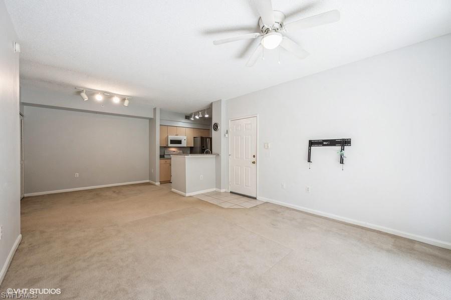 1170 Reserve Way, Unit 107 Naples, FL 34105 - Photo 14 of 41 Unfurnished living room with ceiling fan and light colored carpet