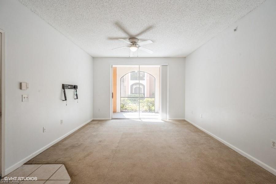1170 Reserve Way, Unit 107 Naples, FL 34105 - Photo 16 of 41 Unfurnished room featuring ceiling fan, light colored carpet, and a textured ceiling