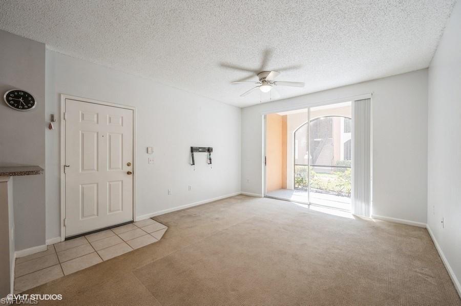 1170 Reserve Way, Unit 107 Naples, FL 34105 - Photo 17 of 41 Carpeted spare room with a textured ceiling and ceiling fan