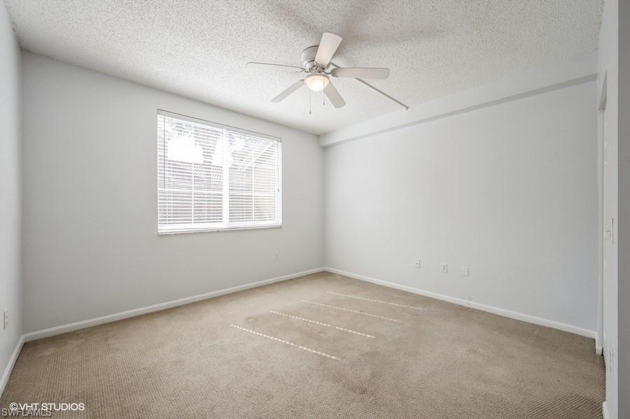 1170 Reserve Way, Unit 107 Naples, FL 34105 - Photo 23 of 41 Carpeted empty room featuring ceiling fan and a textured ceiling