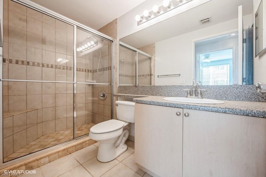 1170 Reserve Way, Unit 107 Naples, FL 34105 - Photo 24 of 41 Bathroom with tile patterned flooring, vanity, toilet, and walk in shower