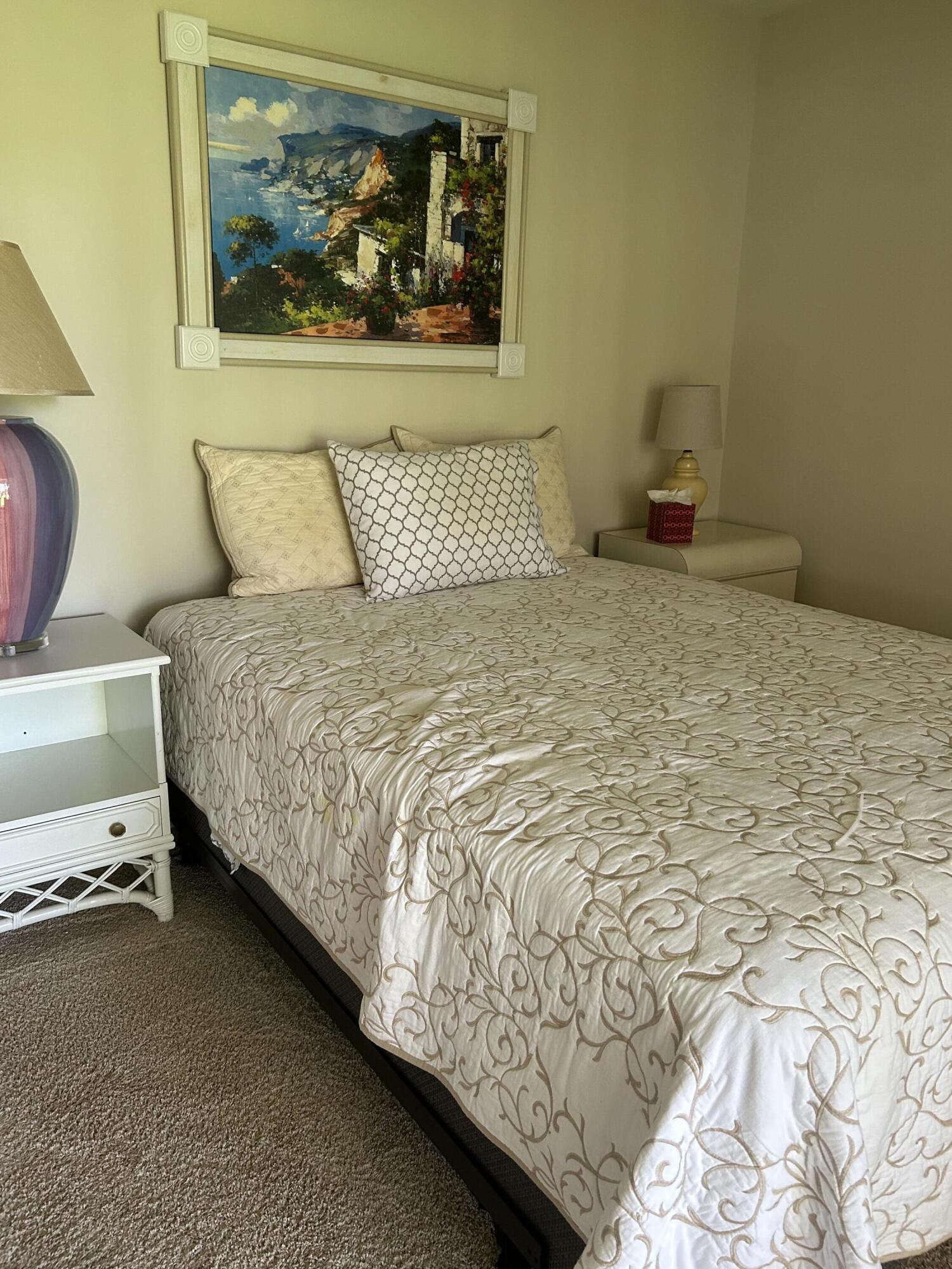 6504 Chasewood Drive, Unit H Jupiter, FL 33458 - Photo 6 of 8 a bedroom with a bed and painting on the wall