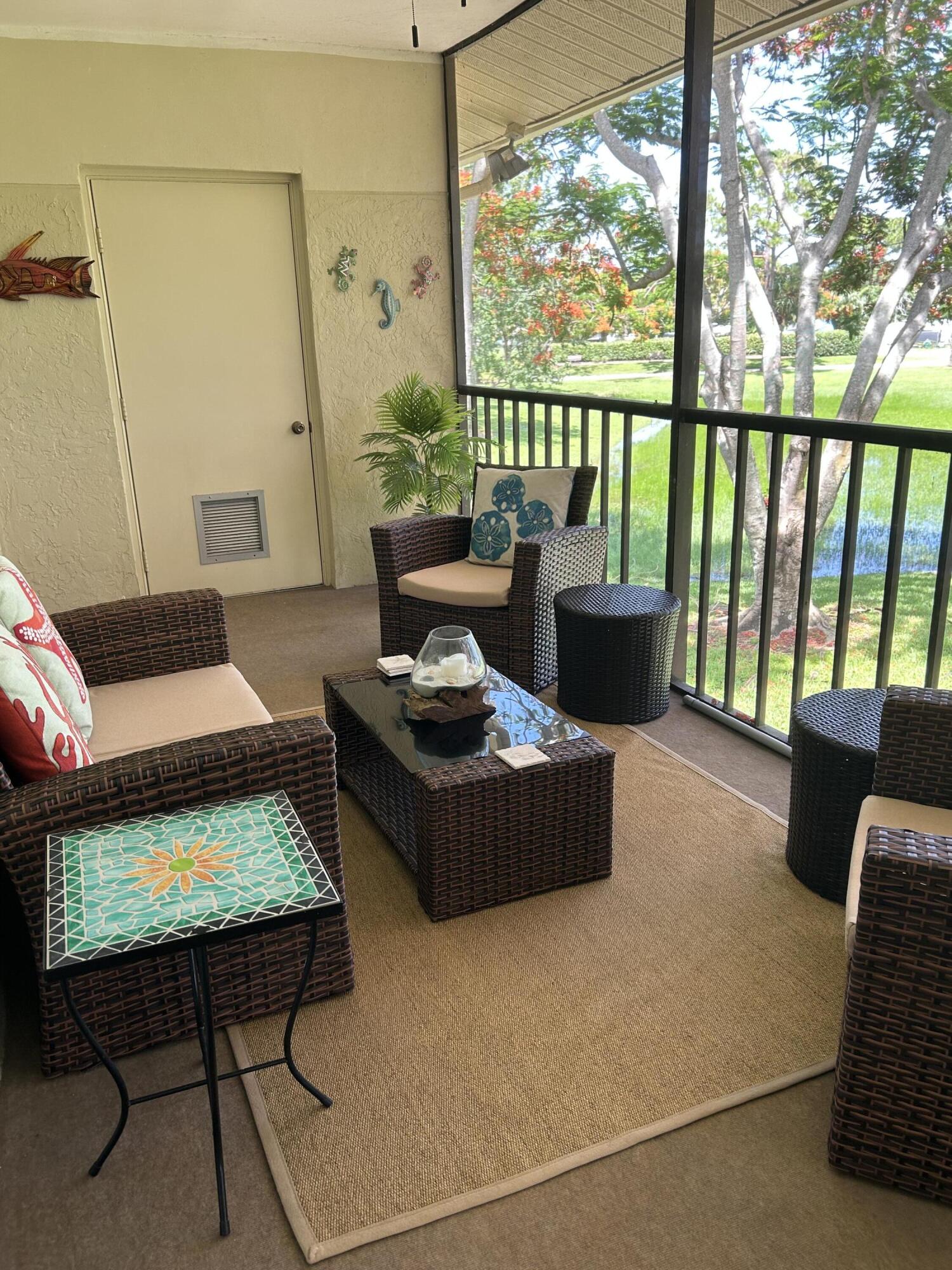 6504 Chasewood Drive, Unit H Jupiter, FL 33458 - Photo 8 of 8 a living room with furniture and a floor to ceiling window