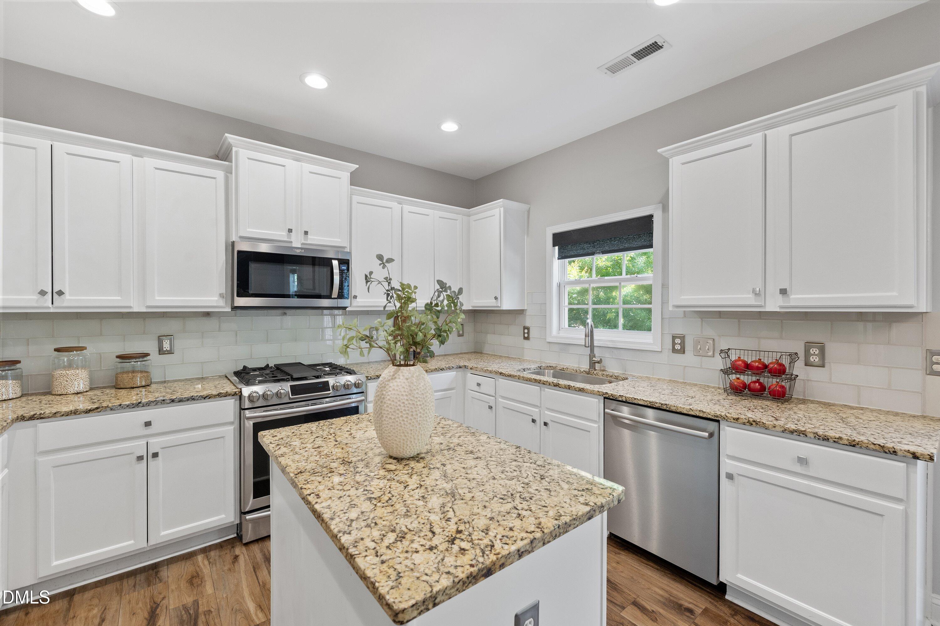 3717 Windmeade Road Wake Forest, NC 27587 - Photo 22 of 51 a kitchen with stainless steel appliances granite countertop a sink stove and cabinets