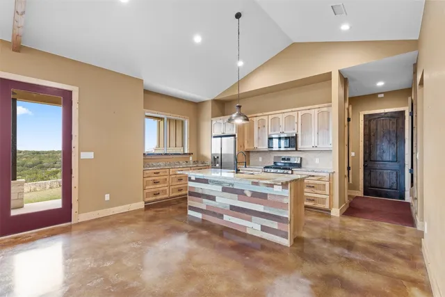 a kitchen with granite countertop a stove and cabinets