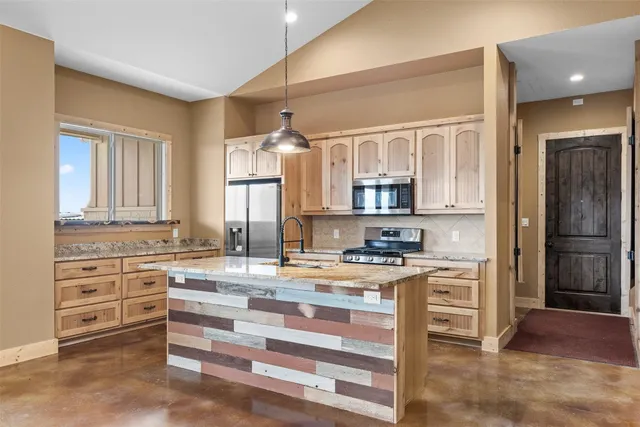 a view of kitchen with granite countertop cabinets and refrigerator