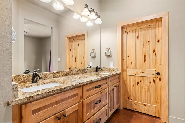 a bathroom with a double vanity sink mirror and toilet