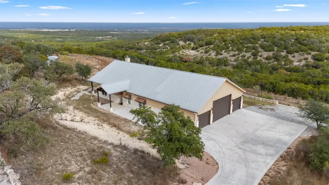 an aerial view of residential houses with outdoor space and trees