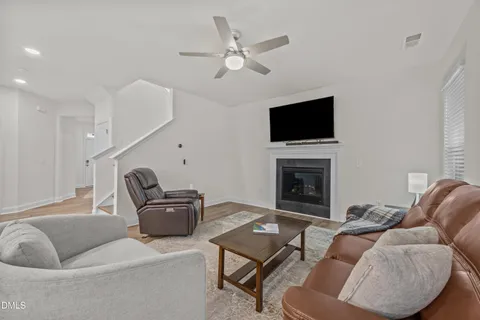 a living room with furniture kitchen view and a chandelier
