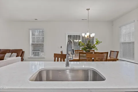 a kitchen with kitchen island a stove a table and chairs in it