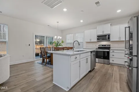 a kitchen with granite countertop a refrigerator stove top oven and sink