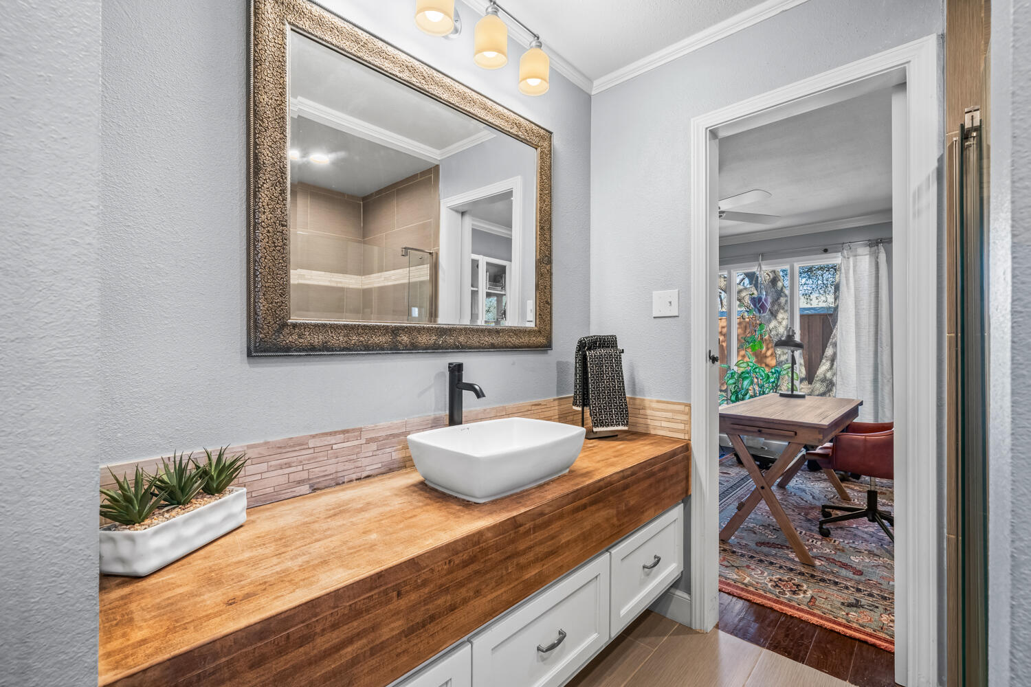 3114 76th Street Lubbock, TX 79423 - Photo 52 of 77 a en suite bathroom with a granite countertop sink and a mirror