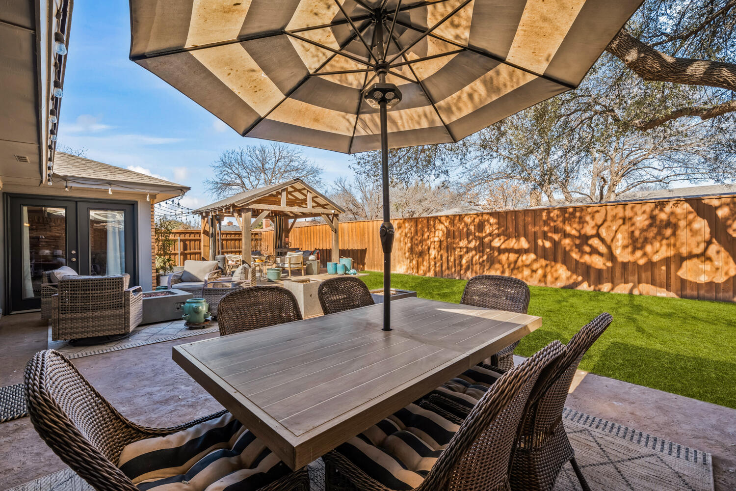 3114 76th Street Lubbock, TX 79423 - Photo 64 of 77 a view of a patio with table and chairs under an umbrella