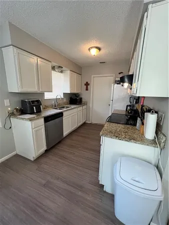 a kitchen with a sink appliances cabinets and a counter top space
