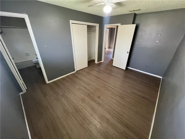 an empty room with wooden floor and stairs