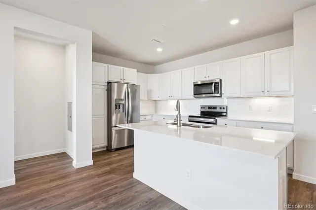 a kitchen with stainless steel appliances a refrigerator stove microwave and sink