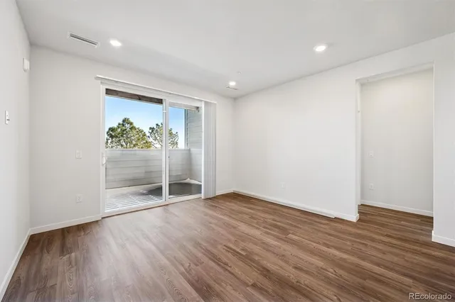 an empty room with wooden floor and door