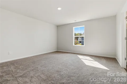 a view of an empty room with window and closet area