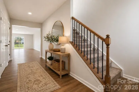a view of a hallway with wooden floor and staircase