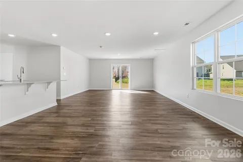 a view of empty room with wooden floor and fireplace
