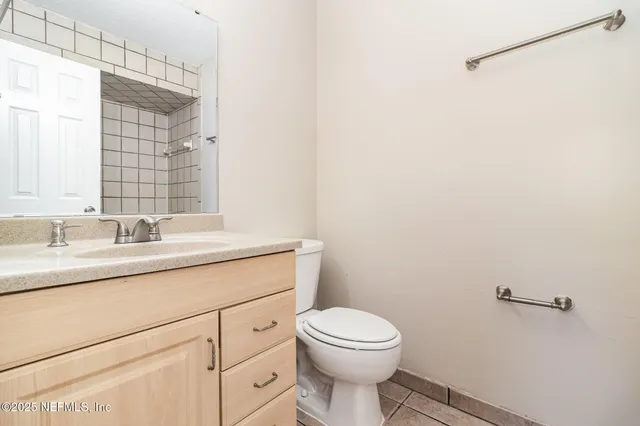 a bathroom with a granite countertop toilet sink mirror and vanity