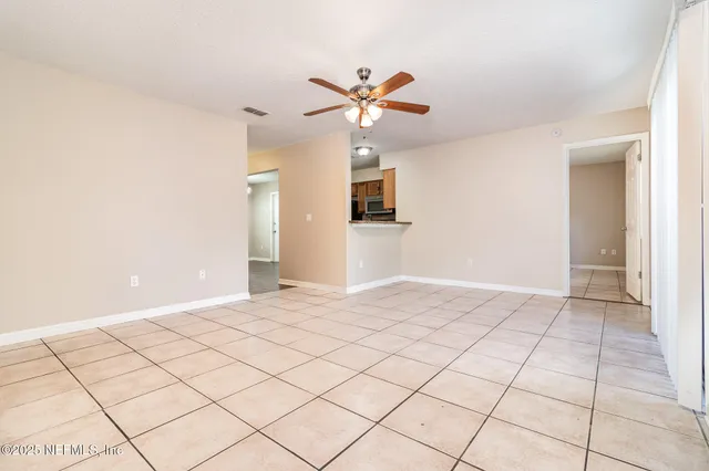a view of a livingroom with a ceiling fan and window