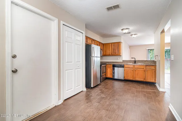 a kitchen with stainless steel appliances a refrigerator and a sink