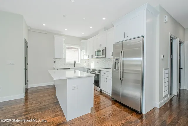 a kitchen with kitchen island a refrigerator sink and cabinets