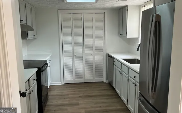 a kitchen with a refrigerator and a sink