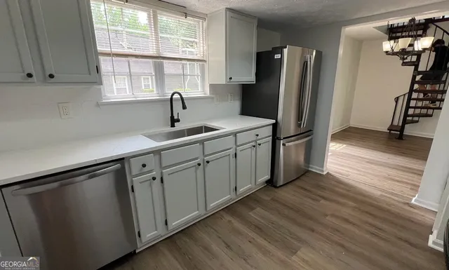 a kitchen with stainless steel appliances granite countertop a refrigerator sink and cabinets
