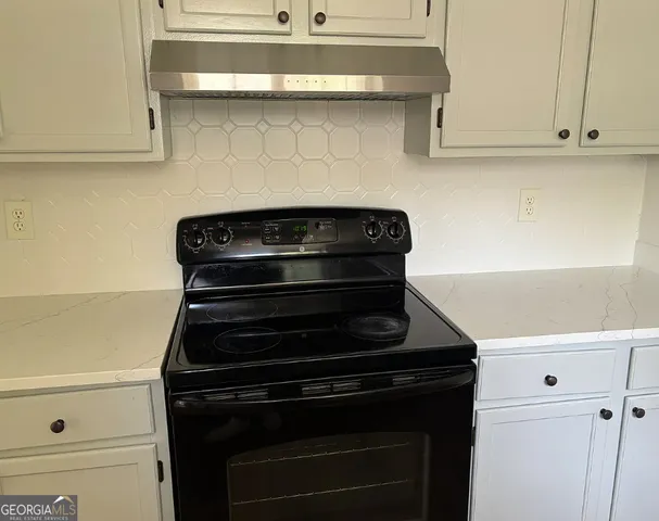 a stove top oven sitting inside of a kitchen