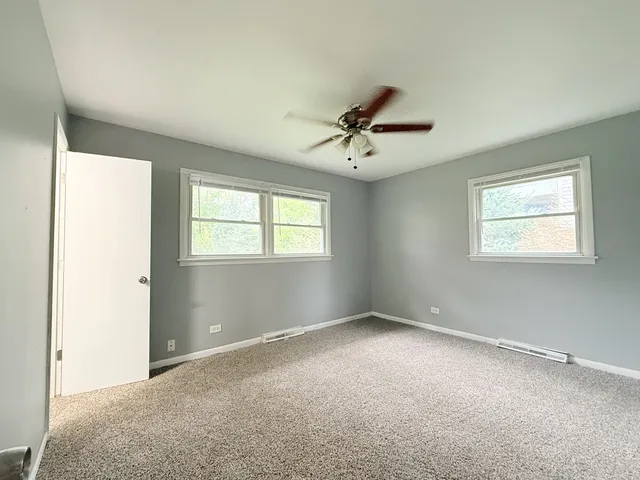 a view of an empty room with a ceiling fan