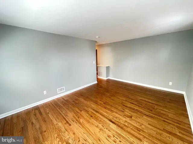 a view of wooden floor in an empty room with a window