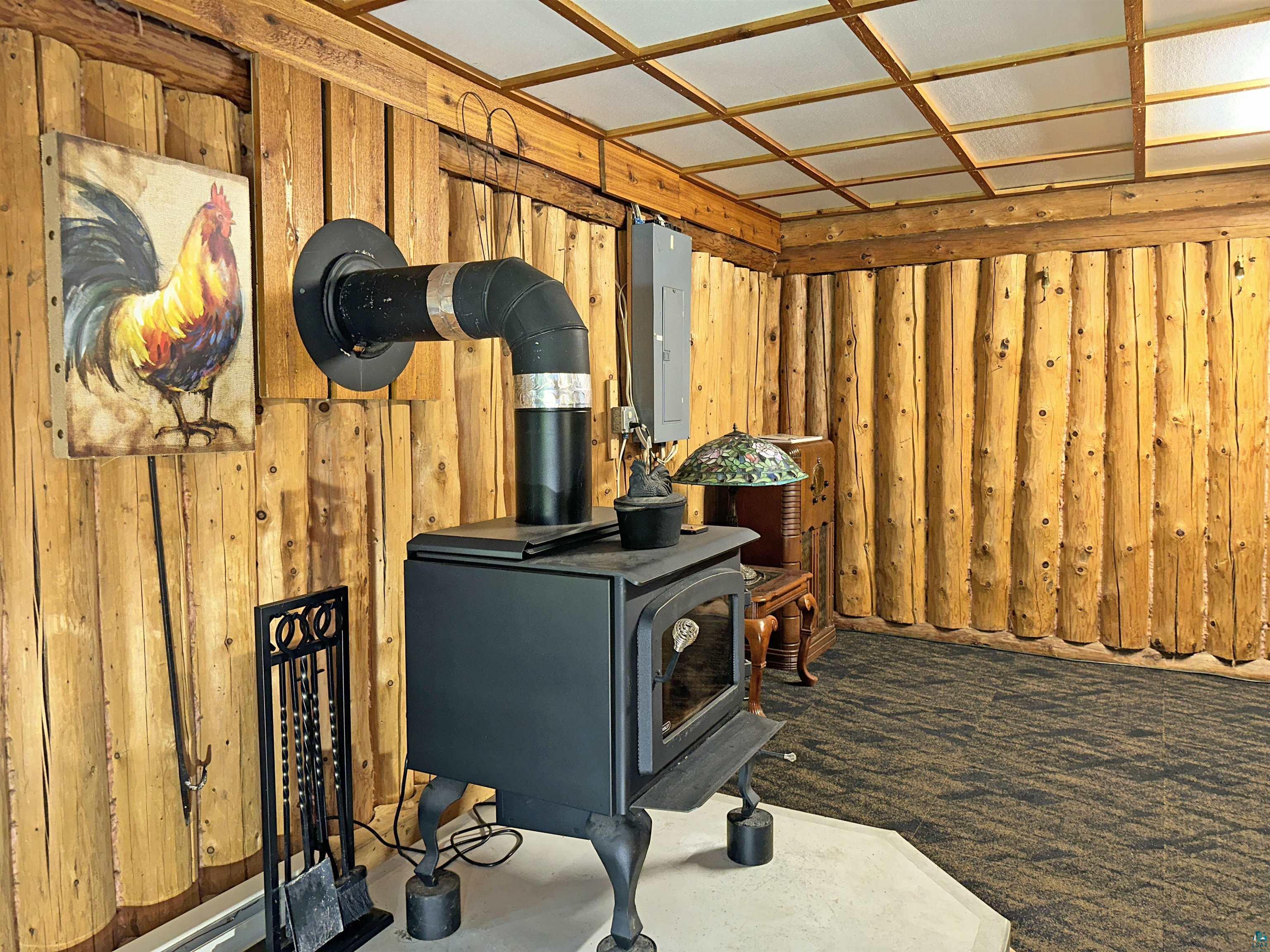 80590 Lenawee Road Herbster, WI 54844 - Photo 8 of 36 Interior space with wooden walls, electric panel, and a wood stove