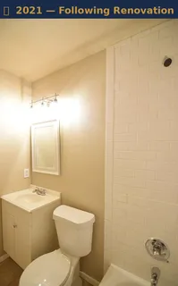 a spacious bathroom with a granite countertop sink a toilet a mirror and shower