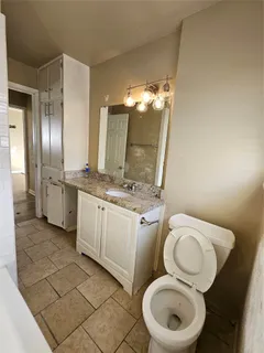 a bathroom with a granite countertop sink a toilet and a bathtub