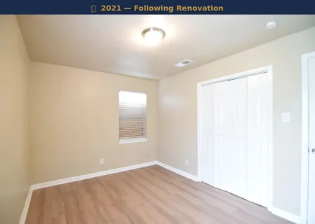 an empty room with a window and a chandelier