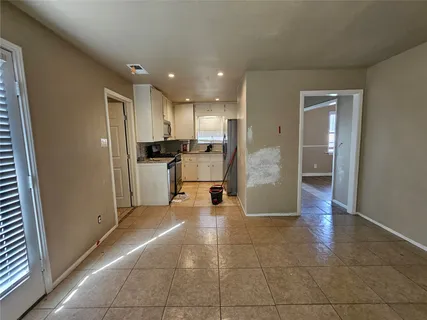 a view of a electric appliances in kitchen and an empty room