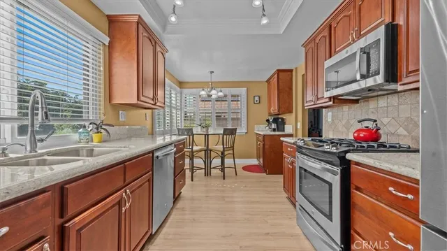 a kitchen with stainless steel appliances granite countertop a stove a sink dishwasher and cabinets with wooden floor