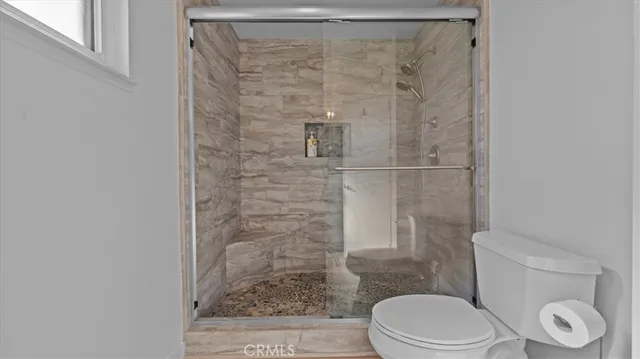 a white toilet sitting next to a shower