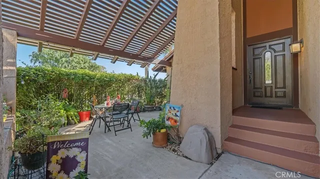 a patio with table and chairs and potted plants