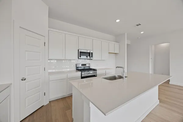 a kitchen with white cabinets and stainless steel appliances