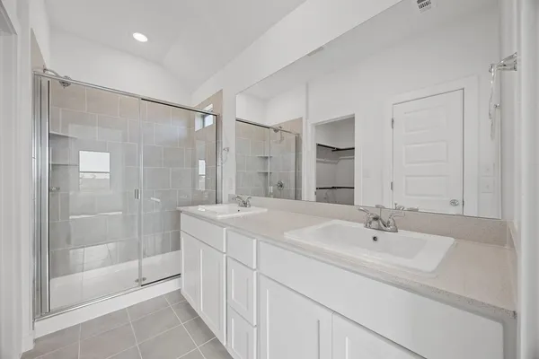 a bathroom with a sink double vanity and shower