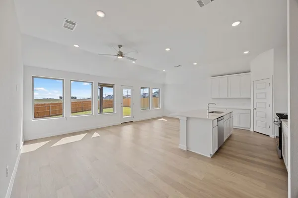 a large kitchen with stainless steel appliances a large counter top and a wooden floors